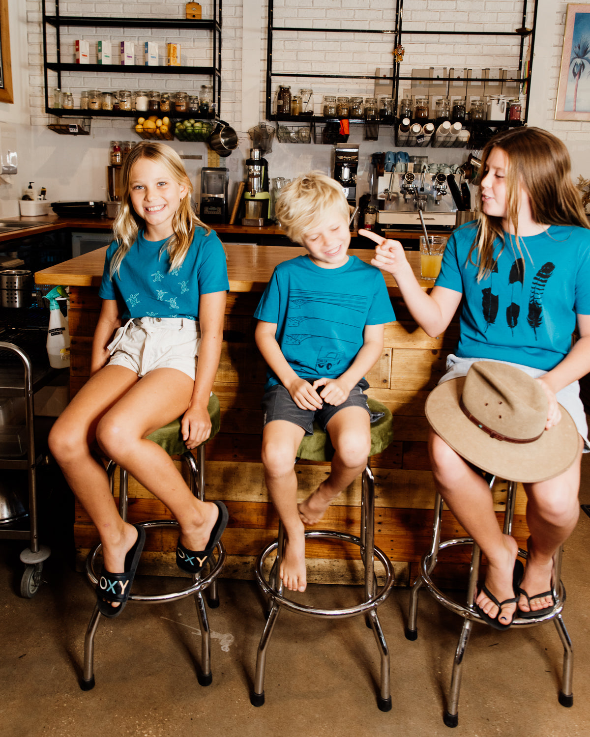 Three kids wearing elk draws organic cotton tshirts.
