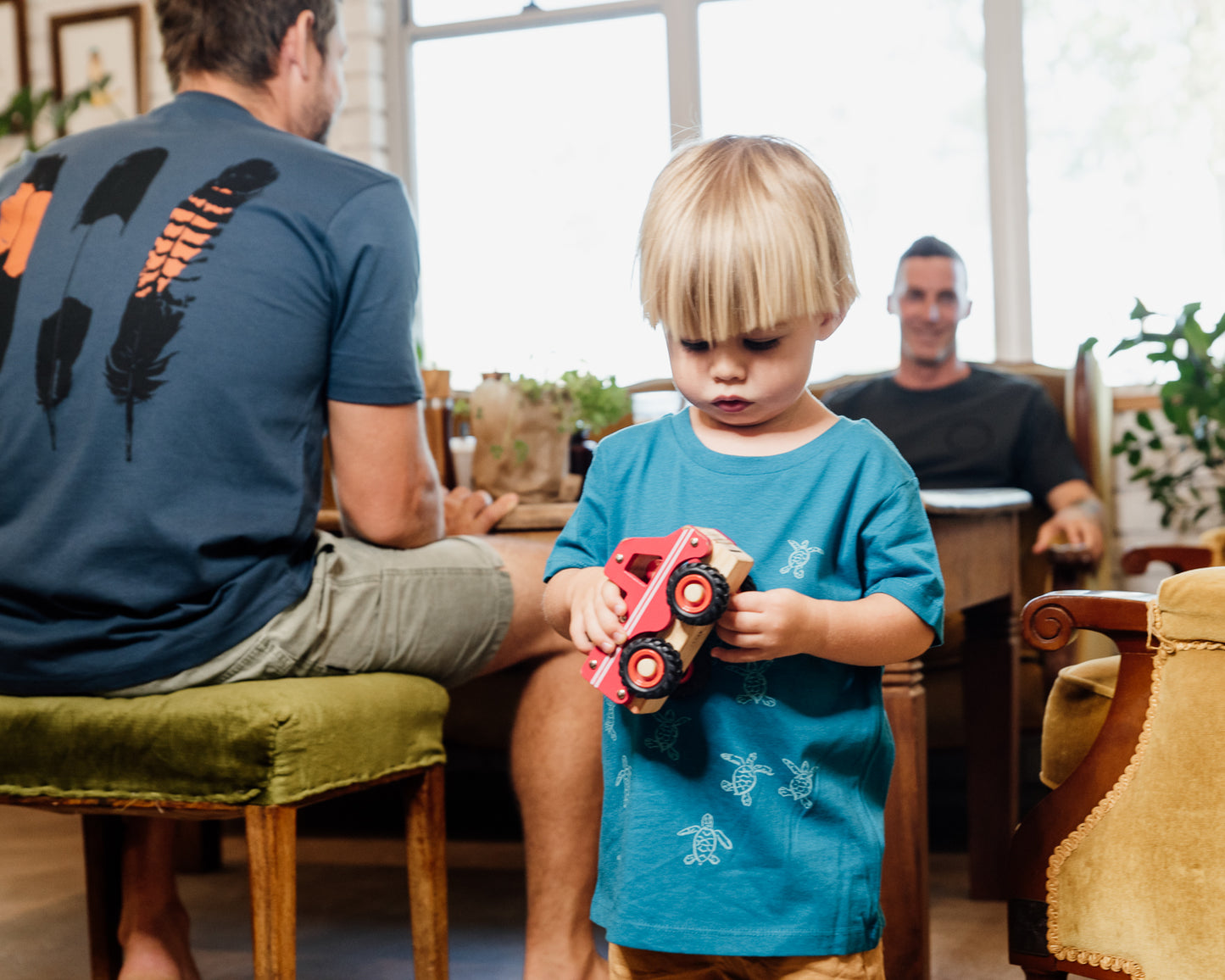 Young girl wearing blue organic cotton tshirt with turtle hatchlings on it.