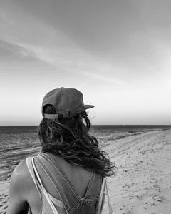 Girl wearing elk draws cap watching turtle hatchlings on beach