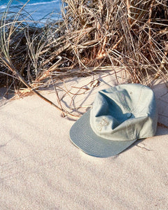 Elk draws coffee pot hat in eucalyptus on sand