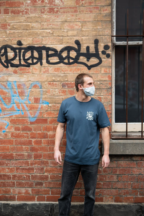 Man with mask in alley wearing covid 19 shirt by elk draws