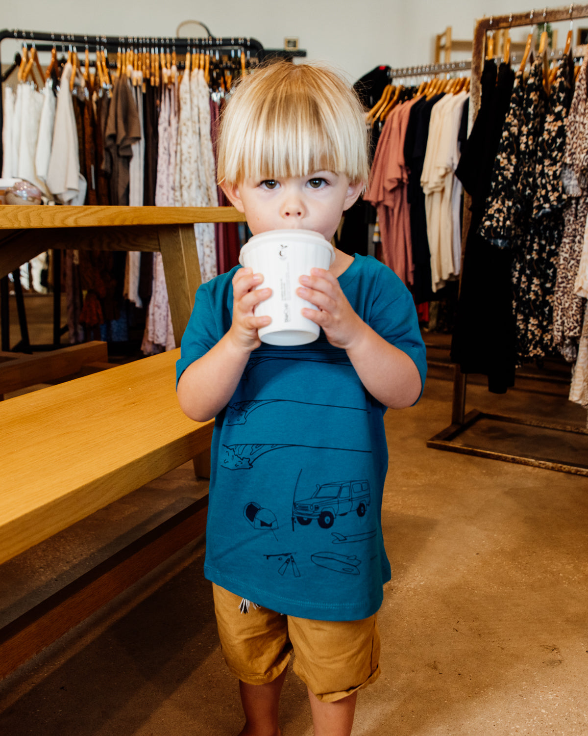 Young boy wearing blue elk draws organic cotton tshirt with troopy camping on it. 