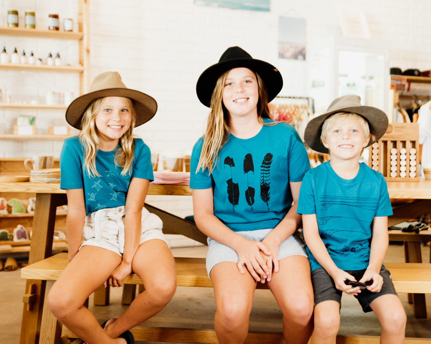 Three kids wearing elk draws organic cotton tshirts. 