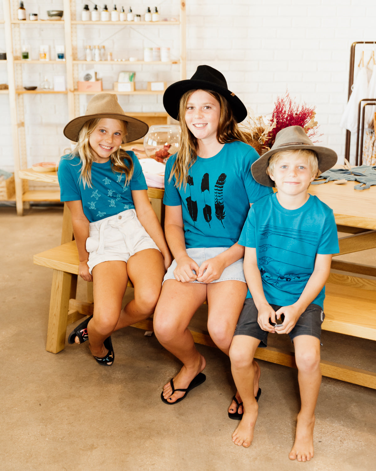 Three kids wearing elk draws organic cotton tshirts. 