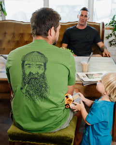 Male wearing elk draws green organic cotton tshirt with a Fisherman on it.