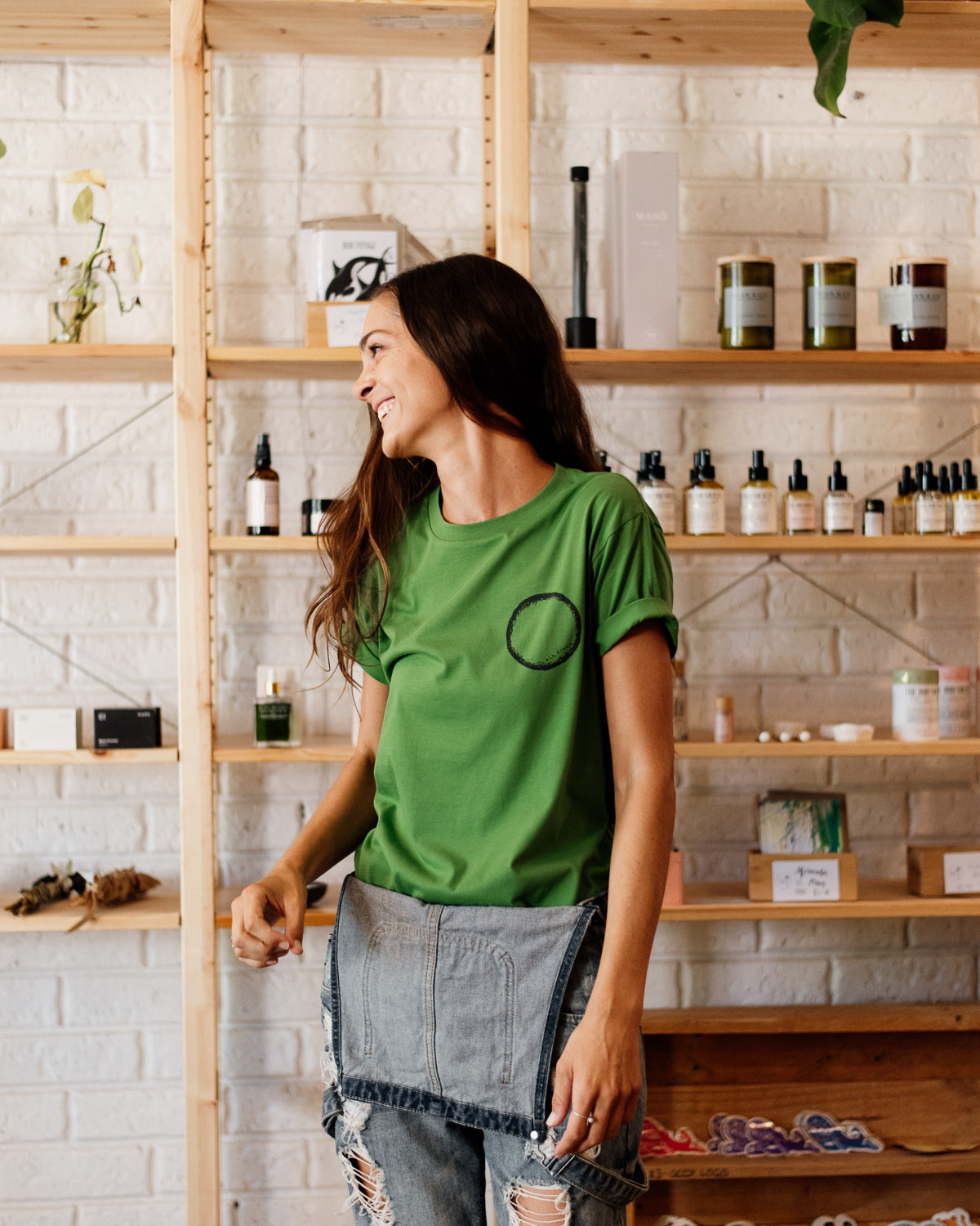 Female wearing elk draws green organic cotton tshirt with a circle on it.